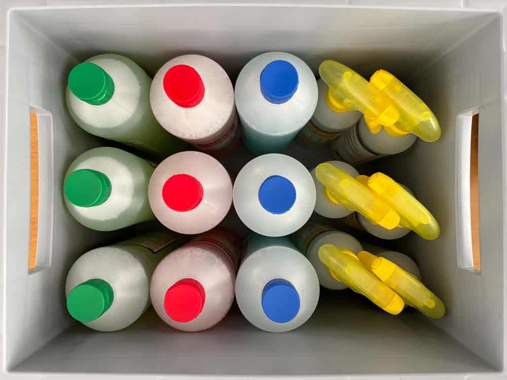 Sechs farbige Flaschen mit verschiedenen Verschlüssen in einem weißen Behälter.